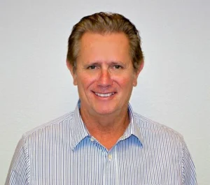 A photograph of a man wearing a polo shirt